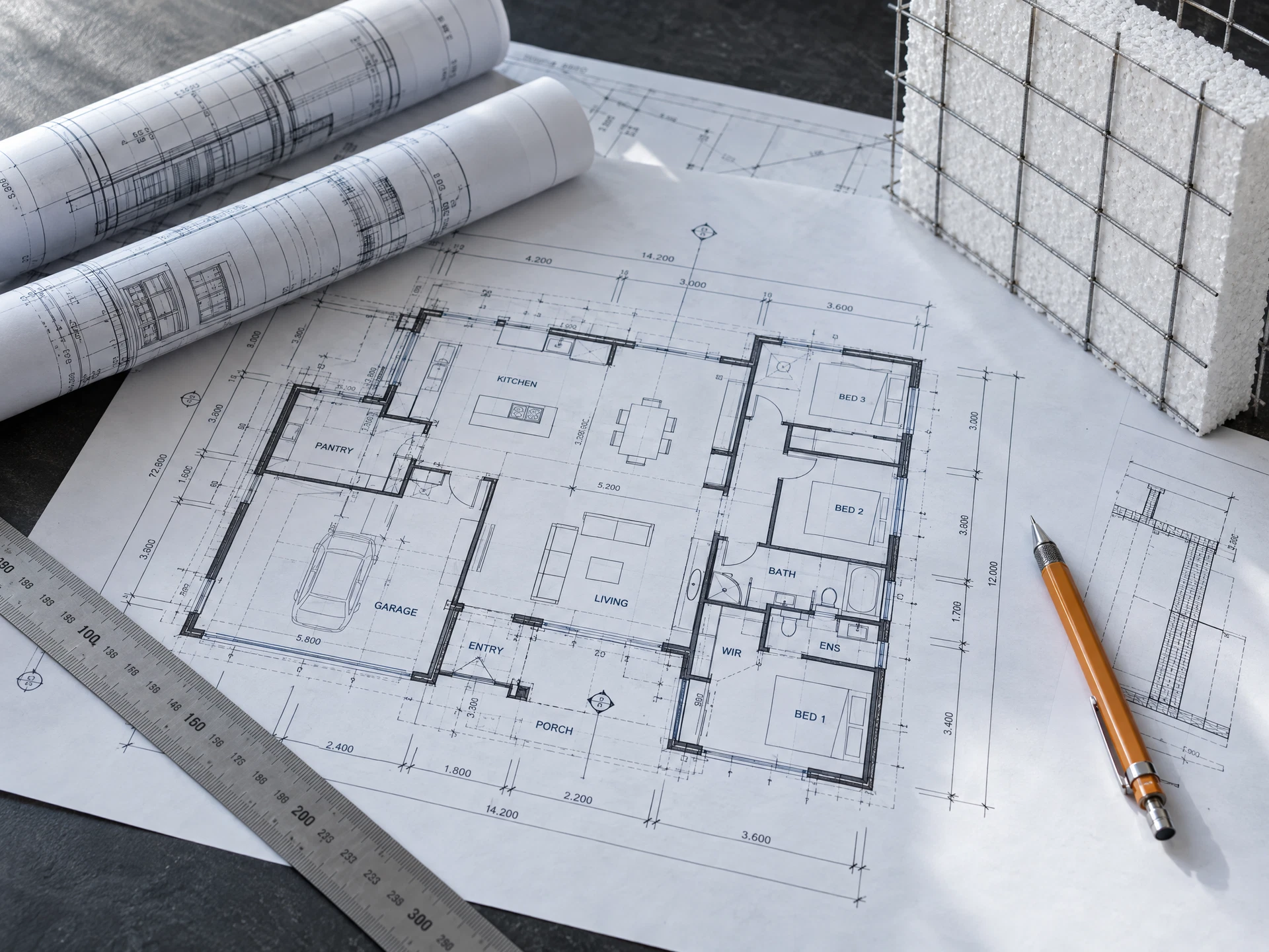 Imagem ilustrativa de planta de engenharia com desenhos arquitetônicos, instrumentos de precisão e amostra de EPS com malha de aço